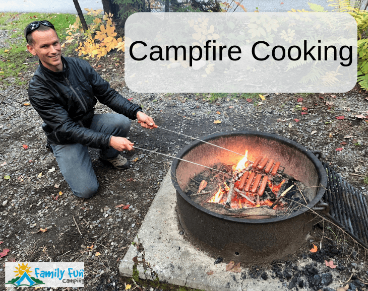 campfire cooking with hotdogs over fire